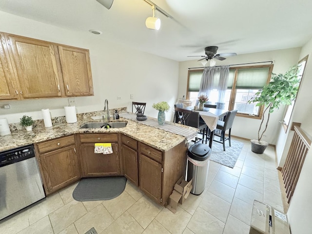 kitchen with sink, dishwasher, light stone countertops, light tile patterned flooring, and kitchen peninsula