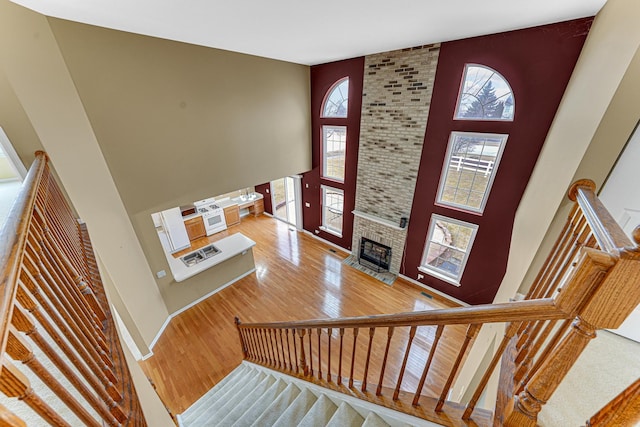 interior space featuring a fireplace, hardwood / wood-style flooring, a wealth of natural light, and a high ceiling