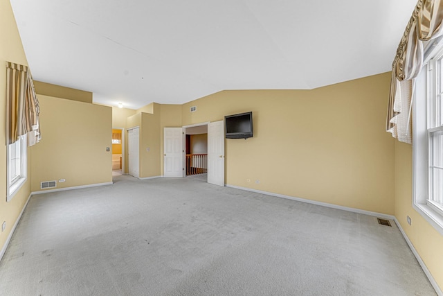 carpeted spare room with lofted ceiling