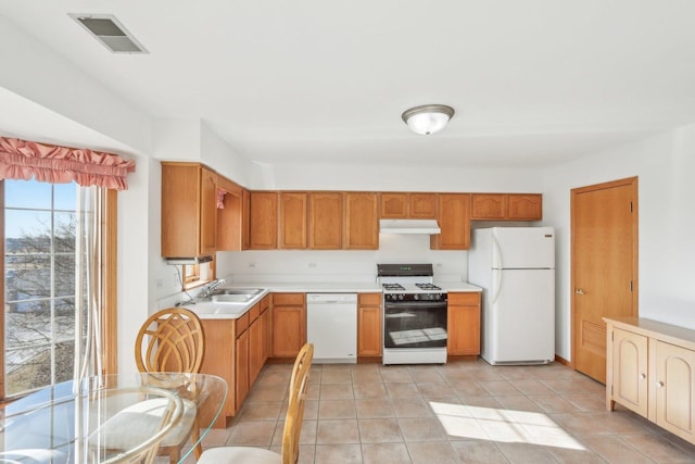 kitchen featuring sink, light tile patterned floors, and white appliances