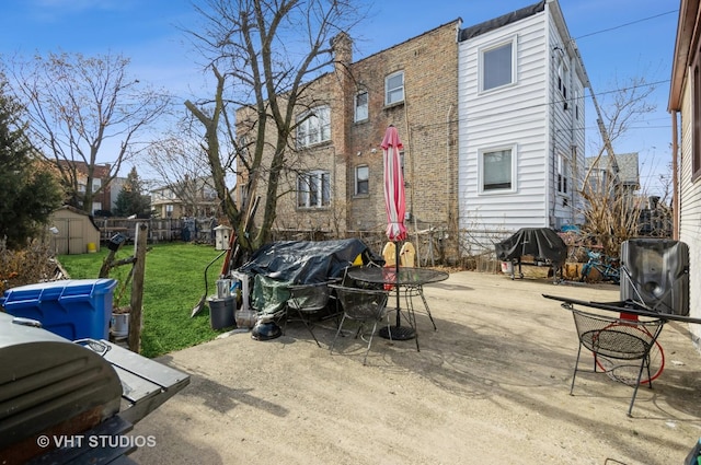 back of property with a storage unit, a yard, and a patio