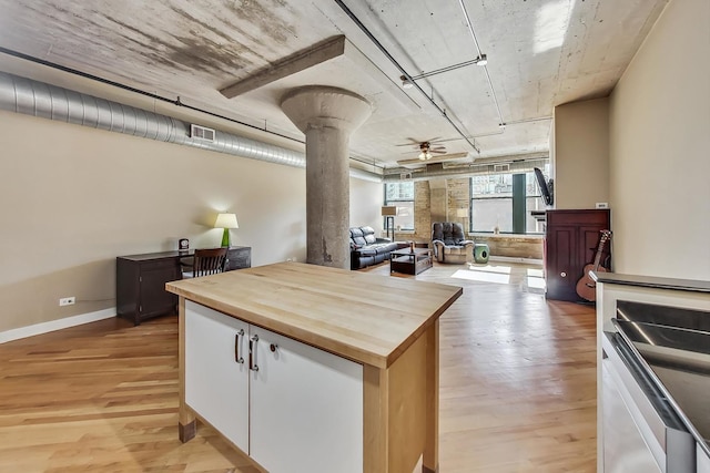 kitchen featuring butcher block countertops, light wood-type flooring, ceiling fan, decorative columns, and white cabinets