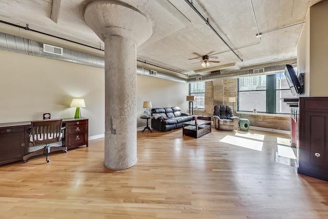 interior space with ornate columns, ceiling fan, and light wood-type flooring