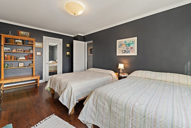 bedroom featuring crown molding and dark wood-type flooring