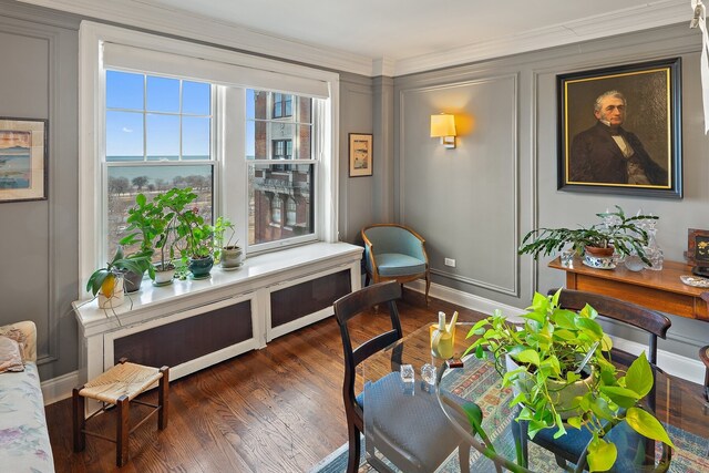 living area with crown molding and dark wood-type flooring