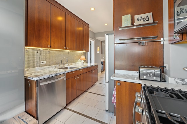 kitchen featuring sink, light tile patterned floors, stainless steel appliances, tasteful backsplash, and light stone counters