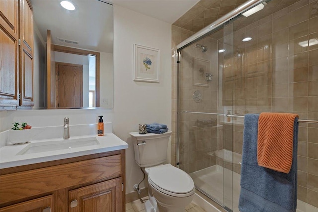 bathroom with toilet, a shower with door, and vanity