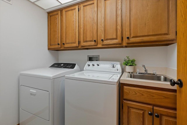 laundry area featuring cabinets, sink, and independent washer and dryer