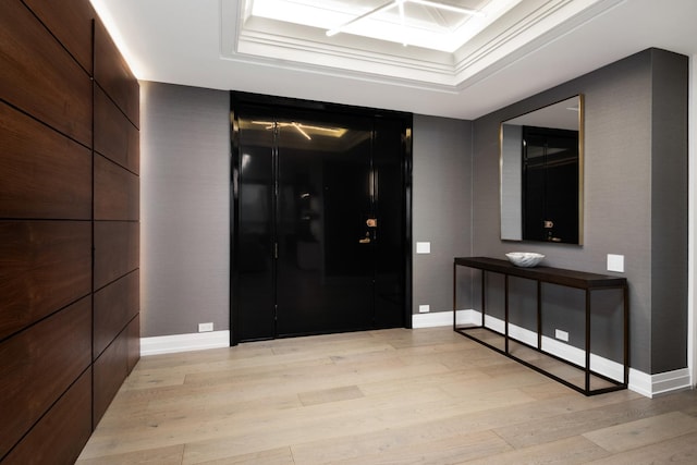 hallway with a raised ceiling and light hardwood / wood-style flooring