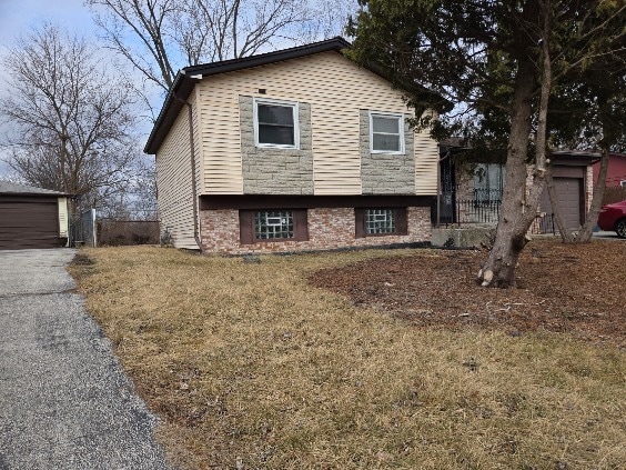 split level home featuring a garage and a front lawn