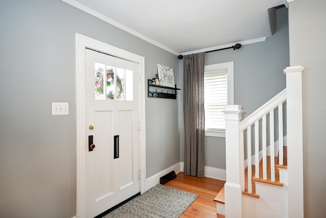 foyer entrance featuring crown molding and light hardwood / wood-style floors