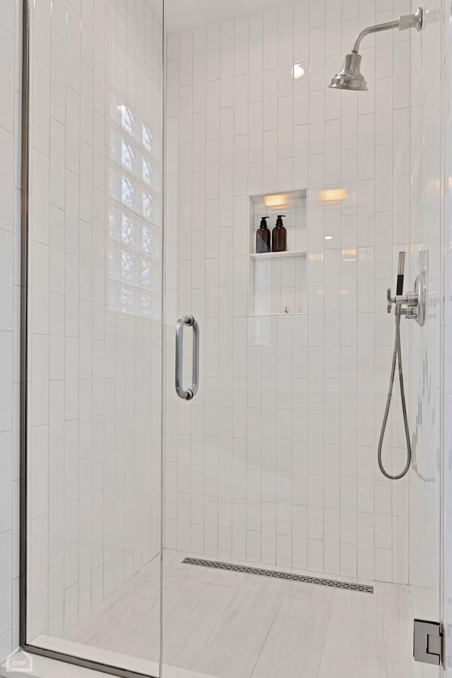 bathroom with a shower with door