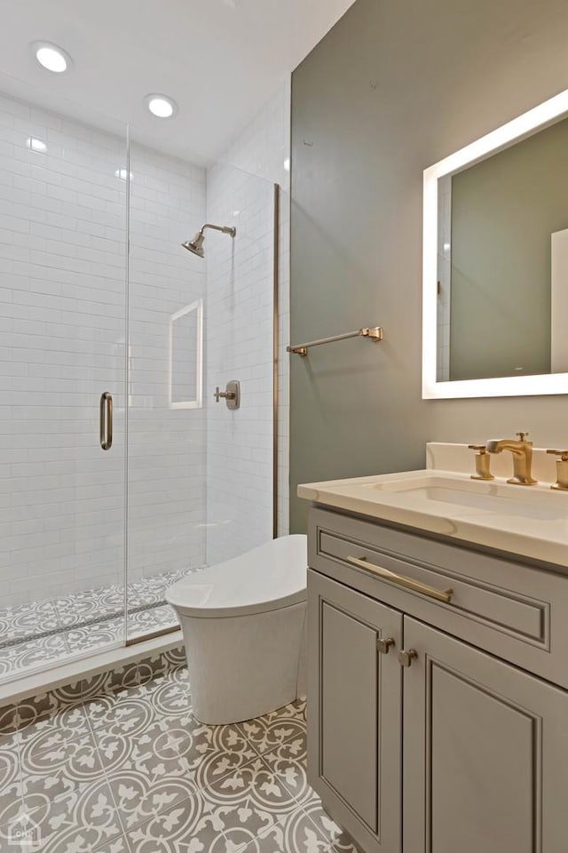 bathroom with tile patterned flooring, vanity, a shower with shower door, and toilet