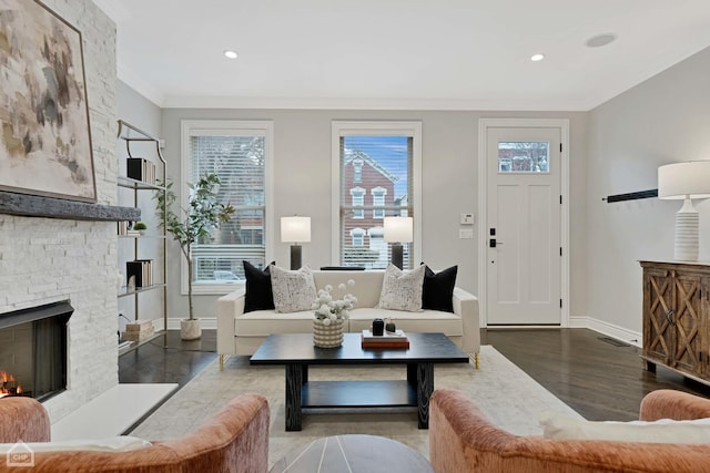 living room with dark hardwood / wood-style flooring, ornamental molding, and a fireplace