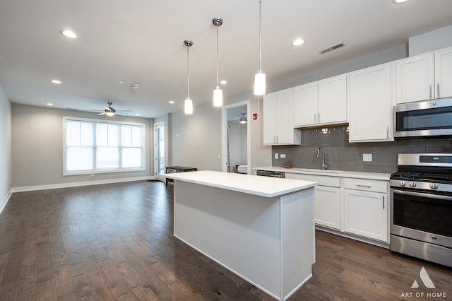 kitchen with open floor plan, light countertops, appliances with stainless steel finishes, and white cabinetry