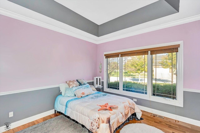 bedroom featuring crown molding and hardwood / wood-style flooring