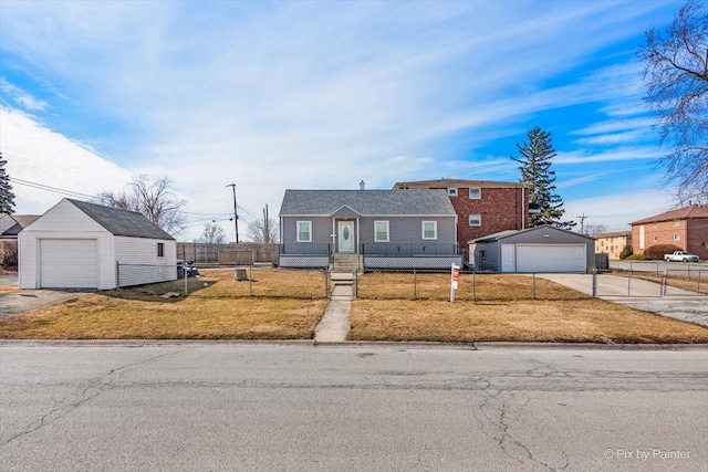 view of front facade featuring a garage, an outbuilding, a fenced front yard, and a front yard