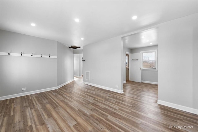 empty room featuring baseboards, visible vents, and wood finished floors