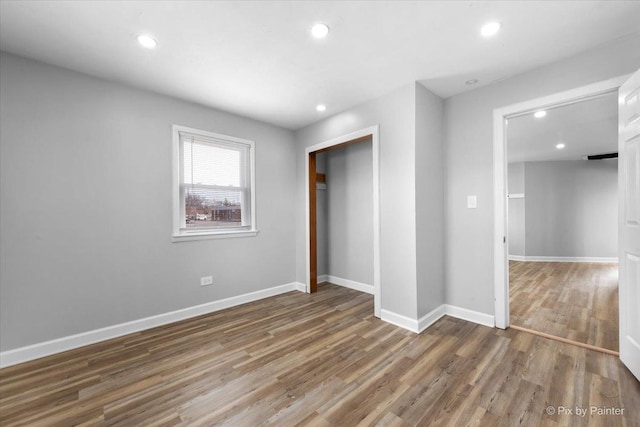 unfurnished bedroom with baseboards, wood finished floors, and recessed lighting