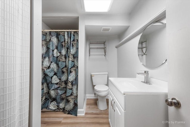 full bathroom with toilet, wood finished floors, vanity, visible vents, and baseboards