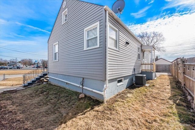 view of side of property featuring crawl space, fence, and central AC unit