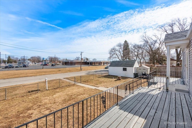 wooden terrace featuring an outbuilding and fence