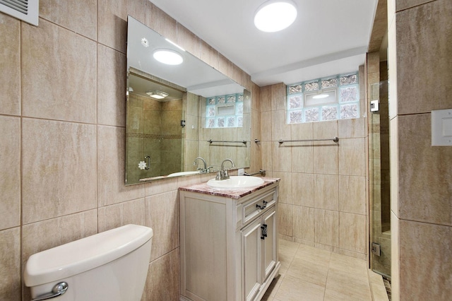 bathroom featuring tile walls, tile patterned floors, toilet, and walk in shower