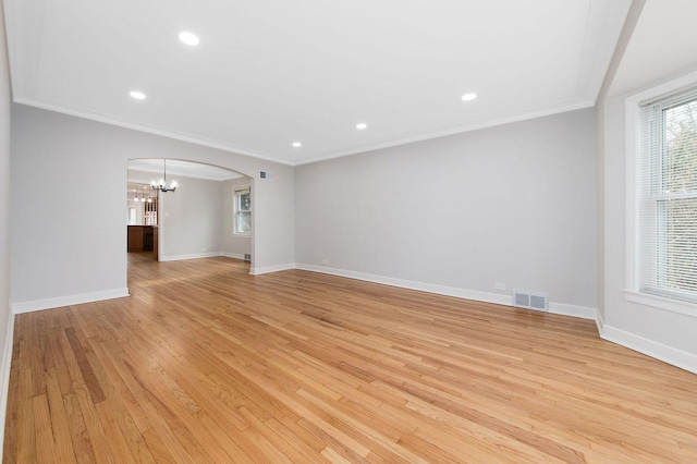 unfurnished living room featuring crown molding, a notable chandelier, and light wood-type flooring