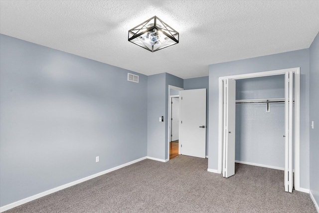 unfurnished bedroom with a closet, visible vents, baseboards, and carpet flooring