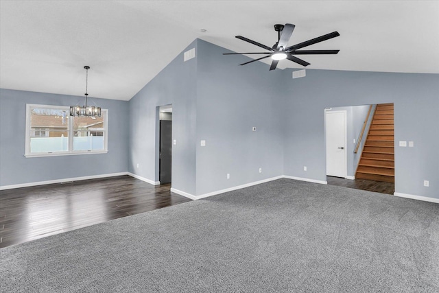 unfurnished living room featuring dark colored carpet, vaulted ceiling, and stairway