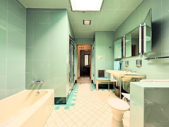 9018 S Oakley Ave, Chicago, IL 60643 - bathroom featuring tile walls, a garden tub, tile patterned flooring, and toilet