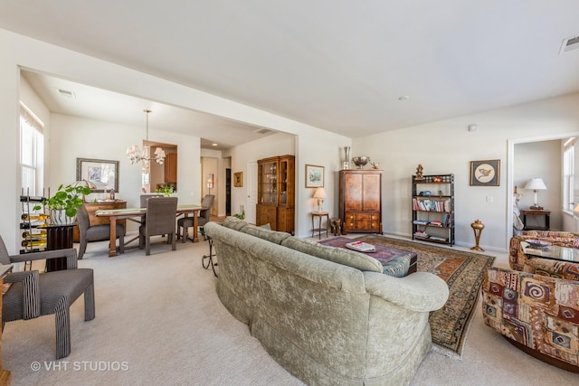 living room featuring a notable chandelier and light colored carpet