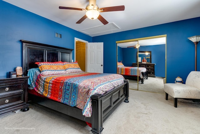 bedroom featuring a closet, a ceiling fan, attic access, and carpet flooring