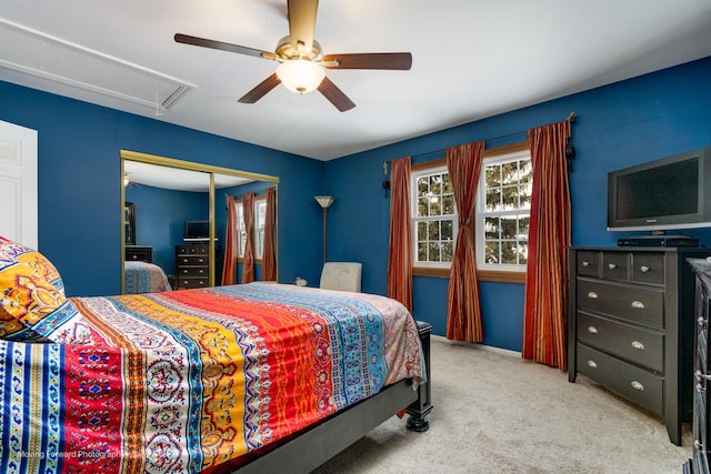 bedroom featuring a closet, attic access, a ceiling fan, and carpet