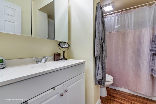 full bathroom with toilet, wood finished floors, and vanity