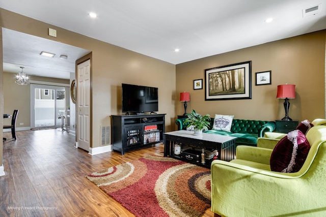 living room with recessed lighting, wood finished floors, visible vents, and baseboards