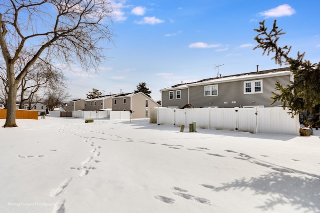 yard covered in snow featuring a residential view and fence