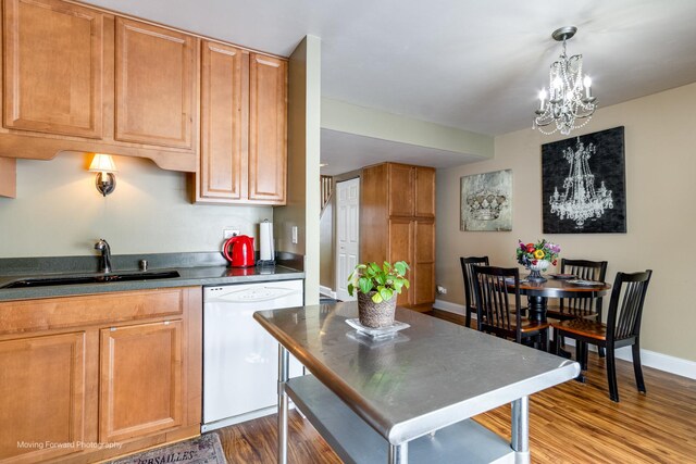 kitchen with dark countertops, dishwasher, dark wood-type flooring, and a sink