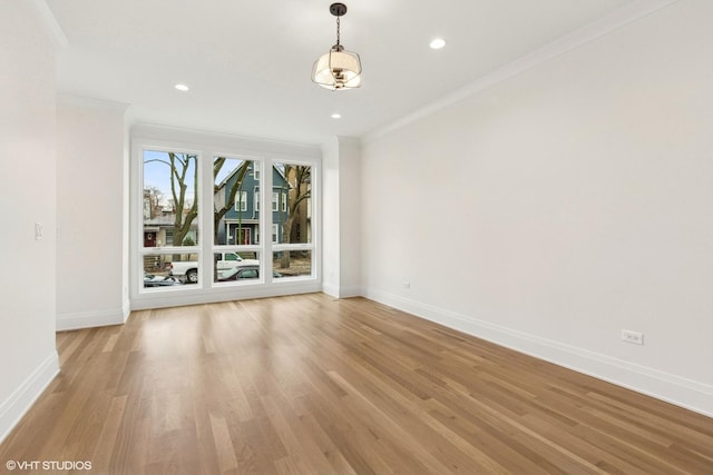 empty room featuring ornamental molding and light hardwood / wood-style flooring