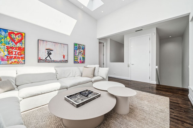 living room featuring a skylight and dark hardwood / wood-style floors