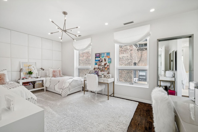 bedroom with wood-type flooring and a chandelier