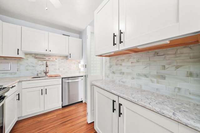 kitchen with sink, dishwasher, backsplash, light hardwood / wood-style floors, and white cabinets