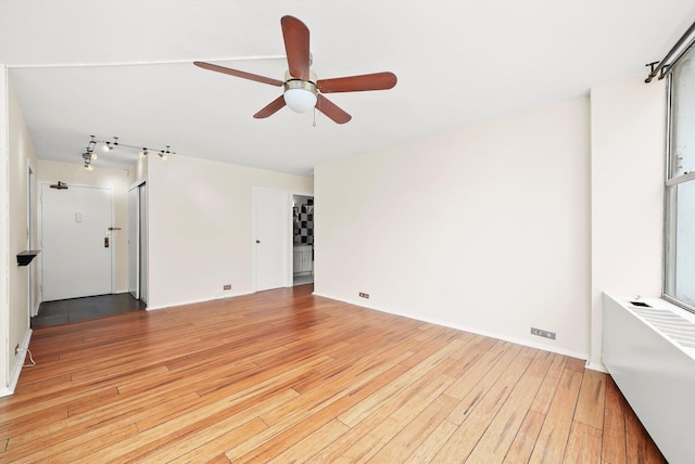 spare room featuring ceiling fan, track lighting, and light hardwood / wood-style floors