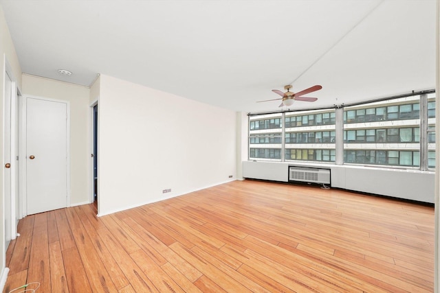 unfurnished living room with ceiling fan, radiator heating unit, and light wood-type flooring