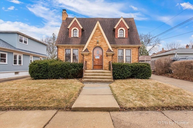 english style home with a front yard