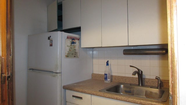 kitchen featuring white cabinetry, tasteful backsplash, sink, and white fridge