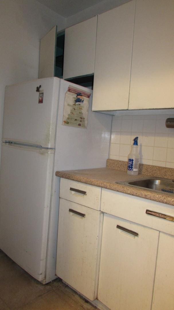 kitchen with decorative backsplash and white cabinets