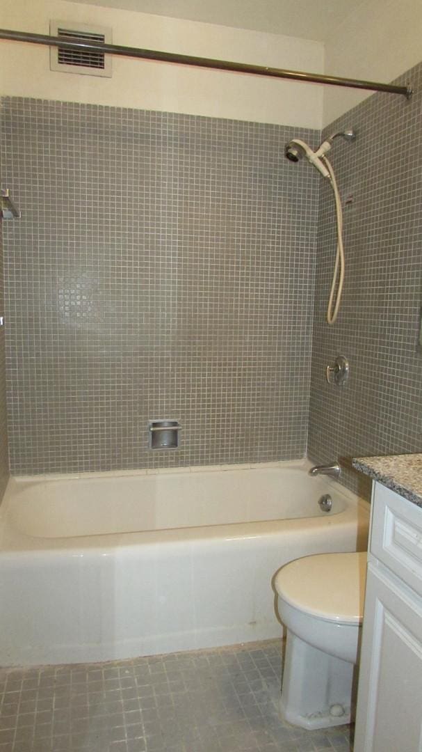 full bathroom featuring toilet, tile patterned floors, vanity, and tiled shower / bath