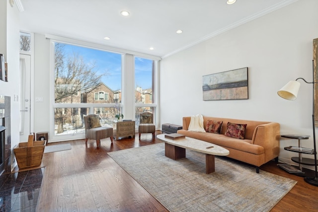 living area with expansive windows, a high end fireplace, crown molding, and wood finished floors