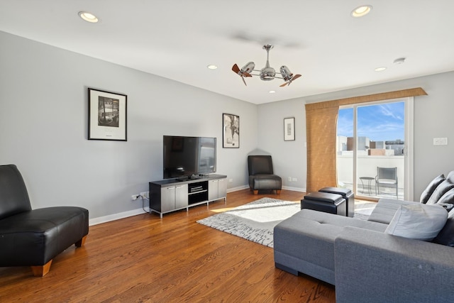 living area with baseboards, wood finished floors, and recessed lighting